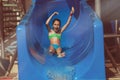 Child sliding down water slide in pool Royalty Free Stock Photo