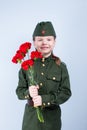 Child girl standing in uniform with red flowers on a blue background