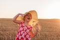 Child girl in straw hat dress in wheat field. Smiling kid in sunglasses sunset countryside. Cottagecore style aesthetic Royalty Free Stock Photo