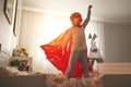 Child girl in a super hero costume with mask and red cloak Royalty Free Stock Photo