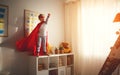 Child girl in a super hero costume with mask and red cloak Royalty Free Stock Photo