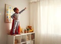 Child girl in a super hero costume with mask and red cloak Royalty Free Stock Photo