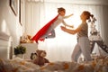 Child girl in a super hero costume with mask and red cloak