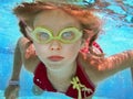 Child girl swim underwater in pool.