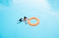 Child girl swims in the pool with lifebuoy