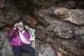 Child girl taking pictures from rock shelter