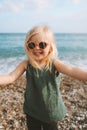 Child girl taking selfie on sea beach baby happy smiling wearing sunglasses 3 years old kid Royalty Free Stock Photo