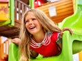 Child girl upside down on playground .