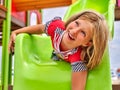 Child girl upside down slippery dip on playground .