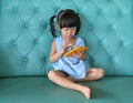 Child girl using smart phone on vintage sofa. asian child girl Royalty Free Stock Photo