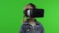 Child girl using VR headset helmet to play game. Watching virtual reality 3d 360 video. Chroma key Royalty Free Stock Photo