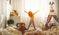 Child girl wakes up and stretches in morning in bed and stretch Royalty Free Stock Photo