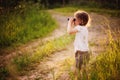 Child girl watching birds with binocular on the walk in summer forest
