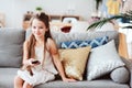 Child girl watching tv at home on cozy couch