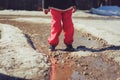 Child girl in waterproof pants running and jumping in puddle on early spring walk Royalty Free Stock Photo