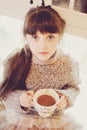 Child girl with a white cup of hot drink Royalty Free Stock Photo