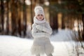 Child girl in a white jacket on the snow in a winter park, childhood and background. Frost and snowy winter, recreation for