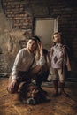 Child girl with woman in image of Sherlock Holmes stands next to English bulldog on background of mirror and old interior. Royalty Free Stock Photo