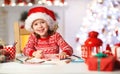 Child girl writing letter santa home near Christmas tree Royalty Free Stock Photo