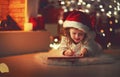 Child girl writing letter santa home near Christmas tree