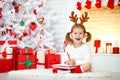 Child girl writing letter santa home near Christmas tree Royalty Free Stock Photo