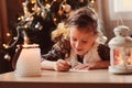 Child girl writing letter to Santa at home. 8 years old girl making gift list for Christmas or New Year at home Royalty Free Stock Photo