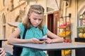 Child girl 10, 11 years old with a smartphone in the city. Royalty Free Stock Photo