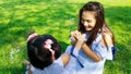 Child give flower to mom on green grass in park Royalty Free Stock Photo