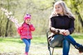 Child giving her her pregnant mother flower outdoor in sunny nature Royalty Free Stock Photo