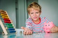 Child giving saved money, boy holding coins taken from piggy bank