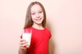 Child with glass of milk on a colored background.