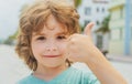 A child with glasses gives a thumbs-up. A kid likes the glasses. Little boy approves. Portrait of a smiling little boy