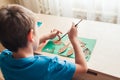 Child glues an applique made of autumn leaves