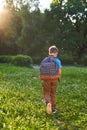 The child goes to school. boy schoolboy goes to school in the morning. happy child with a briefcase on his back and textbooks in Royalty Free Stock Photo