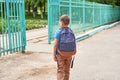 The child goes to school. boy schoolboy goes to school in the morning. happy child with a briefcase on his back and textbooks in Royalty Free Stock Photo