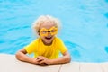 Child with goggles in swimming pool. Kids swim.