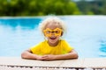 Child with goggles in swimming pool. Kids swim.