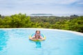 Child with goggles in swimming pool. Kids swim.