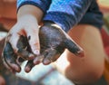 The child got his hands dirty in black nail polish. Hands of the baby in black paint. Baby draws with hands Royalty Free Stock Photo