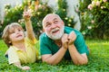 Child with Grandfather dreams in summer in nature. Happy child with Grandfather playing outdoors. Grandpa retiree