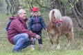 Child, grandfather and pony