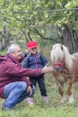 Child, grandfather and pony