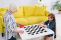 Child and grandparent playing checkers game Royalty Free Stock Photo