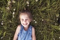 Child on green daisy grass in a summer park sunset time