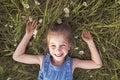 Child on green daisy grass in a summer park sunset time