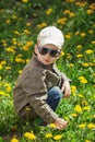 Child on green grass lawn with dandelion flowers on sunny summer day. Kid playing in garden. Royalty Free Stock Photo