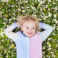 Child on green grass lawn with summer flowers Royalty Free Stock Photo