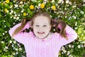 Child on green grass lawn with summer flowers