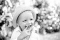 Child on the green grass in summer park. Baby face closeup. Funny launching kid boy close up portrait. Blonde kid Royalty Free Stock Photo