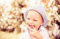 Child on the green grass in summer park. Baby face closeup. Funny launching kid boy close up portrait. Blonde kid Royalty Free Stock Photo